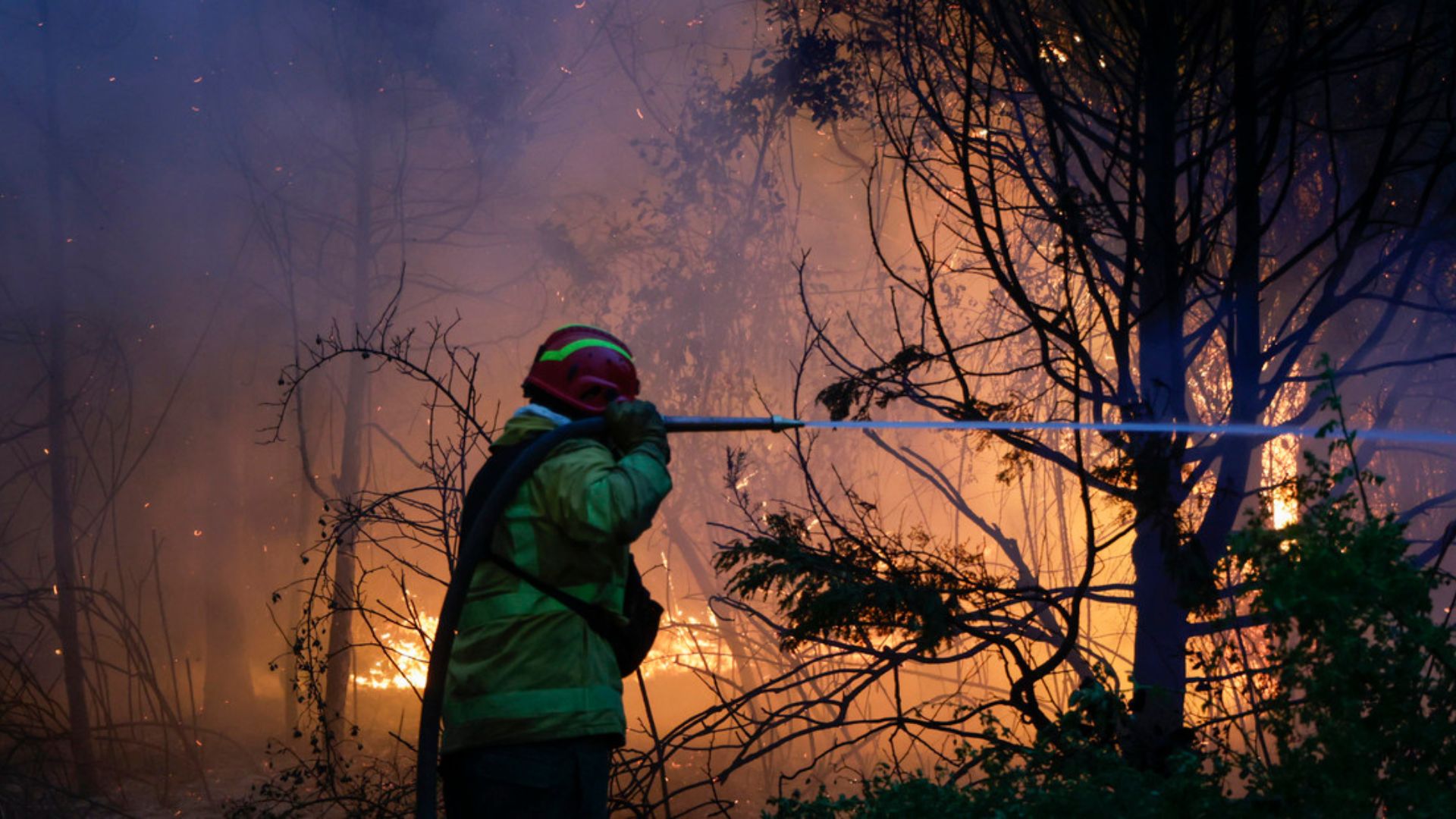 Bombero apagando fuego con una manguera